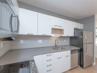 modern white kitchen cabinets with quartz countertops and stainless steel appliances in an Ames Shovel Works apartment in North Easton, MA